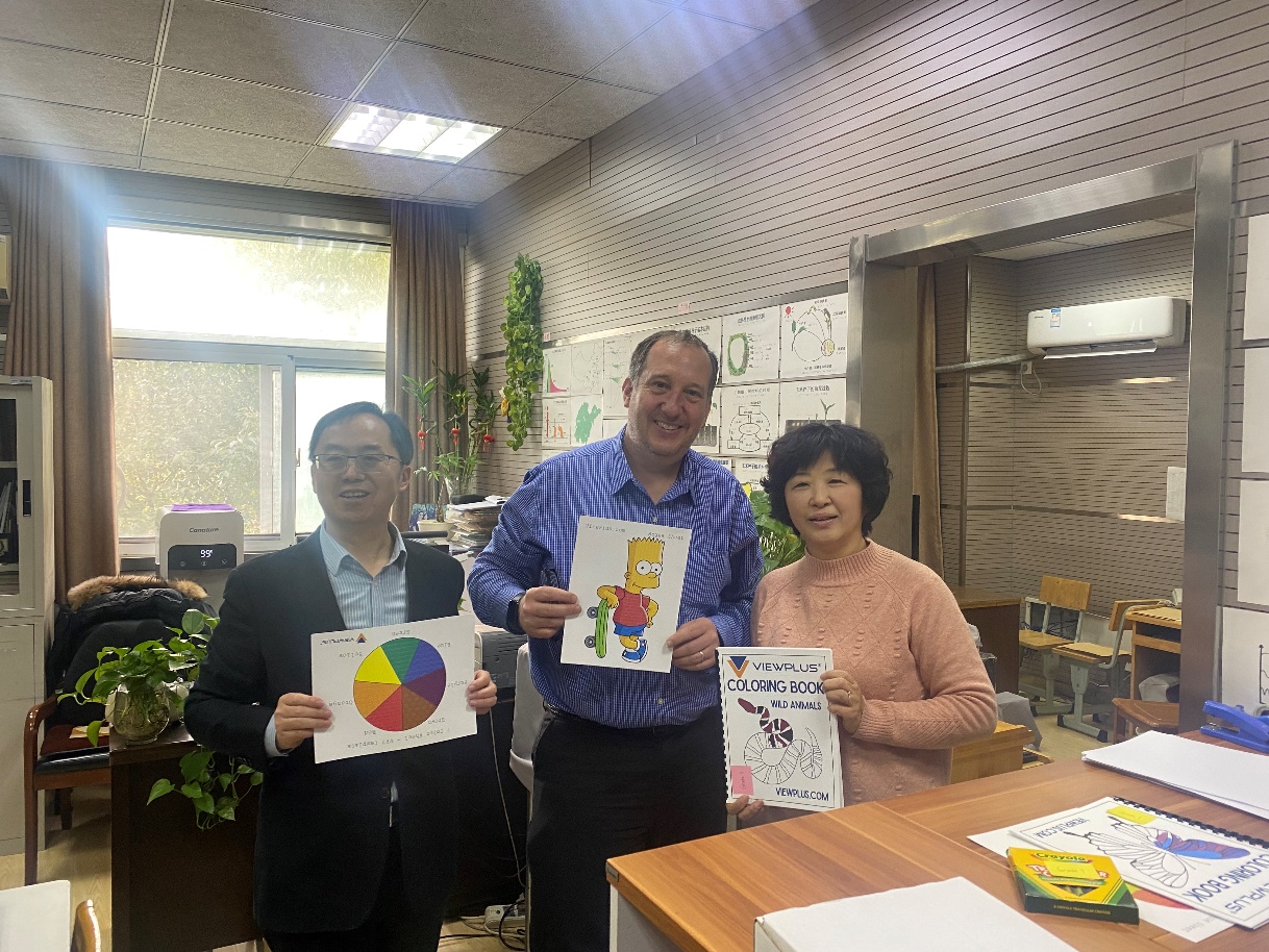 Dan showing off cartoons and coloring books at Nanjing Blind School.